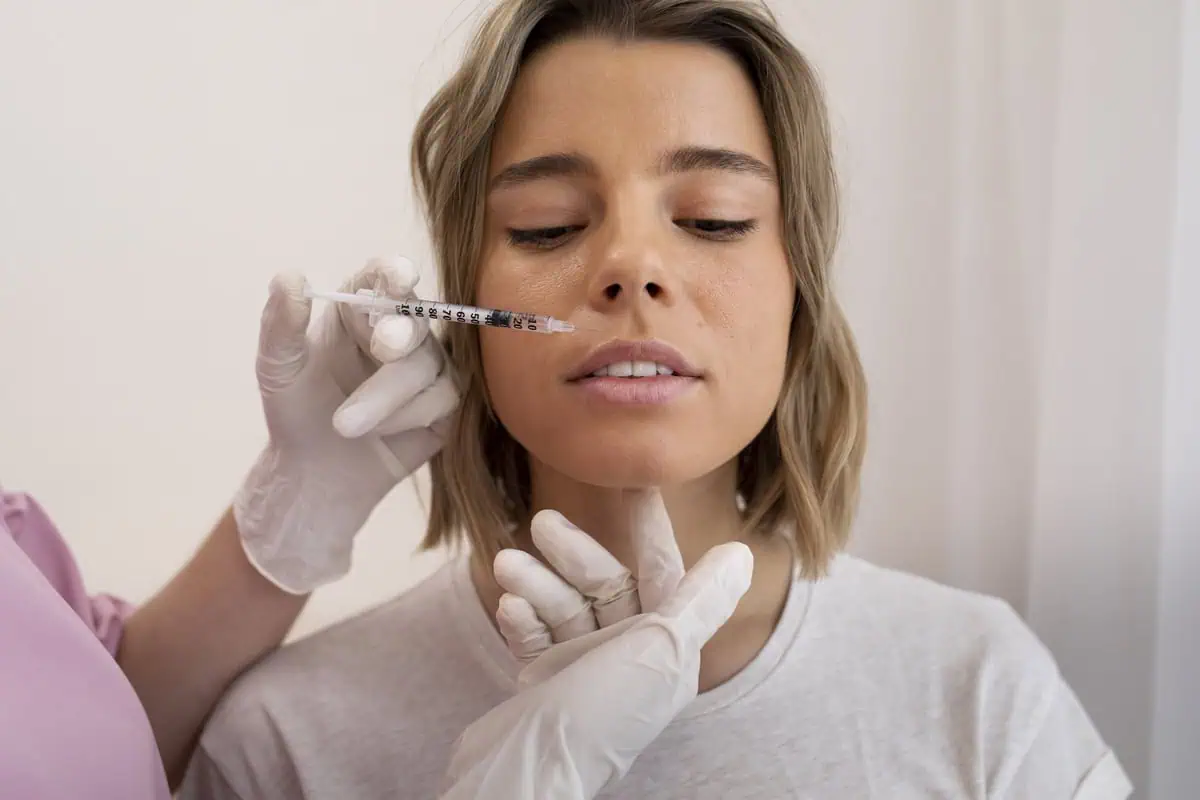Woman receiving facial fillers injection