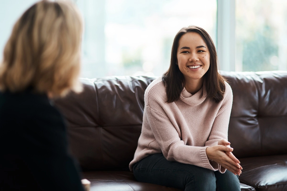 Smiling woman in a relaxed medical aesthetic consultation with a provider in Elko.