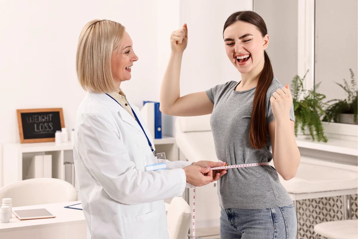 Healthcare provider measuring a woman's waist during the first consultation for a personalized medical weight loss program, explaining what to expect in the first 30 days.